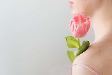 romantic tender portrait of a young woman with pink fresh tulipsの写真素材