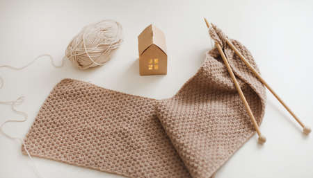 Knitting needles with threads, beige yarn. Hobby for women concept. Knitting accessories.