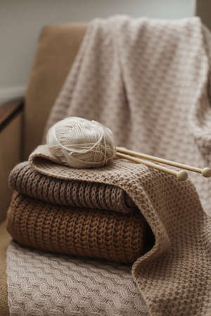 Knitting needles with threads, beige yarn. Hobby for women concept. Knitting accessories.の写真素材