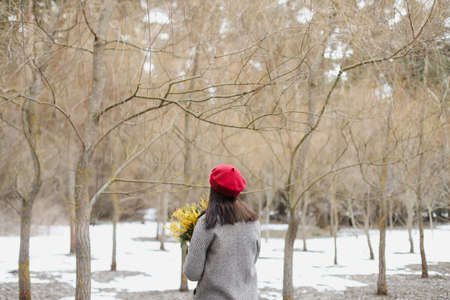 beautiful portrait of a young woman with mimosa flowers outdoors.