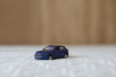 Miniature blue plastic toy car on textile material macro shot. close-up.の写真素材