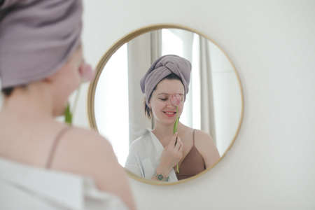 spring portrait of a young woman with pink fresh tulip on white background.の写真素材