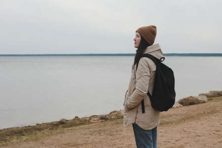 Portrait of young woman in a hat looking over the sea or the ocean, enjoying amazing nature, feeling of freedomの写真素材