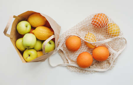 Lemons in reusable bag. Zero waste concept with string bag, mesh bag, grosery bag with fruits on...