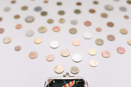 Open wallet with different coins isolated on white background top view. Financial crisis, poverty, lack of money conceptの写真素材
