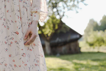 Close up of a woman hand at sunset in the countryside outdoors in summer. Romantic conceptの写真素材