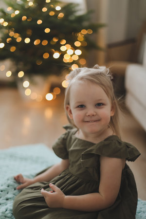 Cute little child girl and the Christmas tree indoors. Merry Christmas and Happy New Year conceptの写真素材