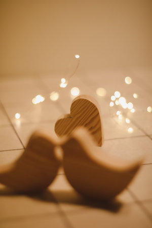 two wooden birds and heart made by bokeh lights background. Valentines day, Wedding, Easter card with wooden figures of birds, home decorの写真素材