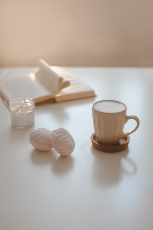 coffee cup, flower, candle and a book on a white table background top view. minimal home interior decorの写真素材
