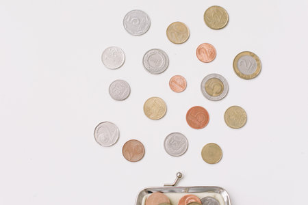 Open wallet with different coins isolated on white background top view. Financial crisis, poverty, lack of money conceptの写真素材
