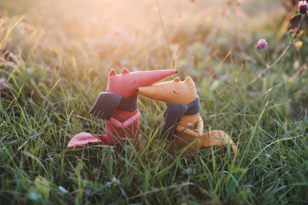 Cute little handmade toy fox in green grass. Childhood, baby, holiday, people, hobby, emotions concepts.の写真素材