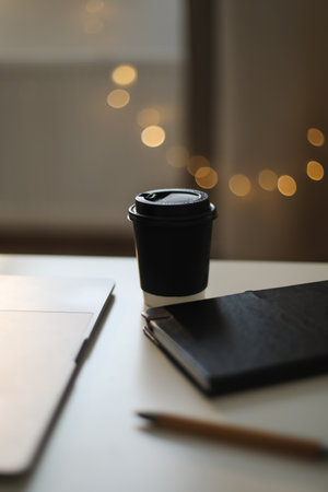 Desk office with laptop, phone, coffee cup, pen on black table. Flat lay top view copy space. Home office. Inspiration moment, workspace or coffee break in the morning. selective focus.の写真素材