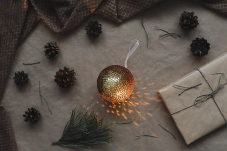 Christmas composition on craft paper background with gift box, fir branches, toys, copy space for your congratulationsの写真素材