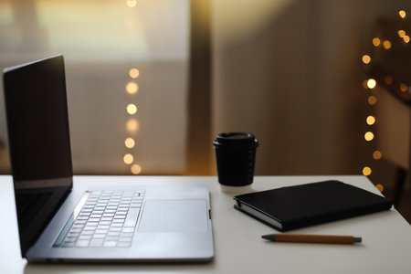 Desk office with laptop, phone, coffee cup, pen on black table. Flat lay top view copy space. Home office. Inspiration moment, workspace or coffee break in the morning. selective focus.の写真素材
