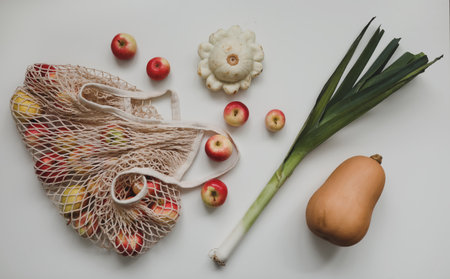 autumn harvest with sqush, pumpkin, red apples in a mesh shopping eco bag. zero waste, no plastic conceptの写真素材