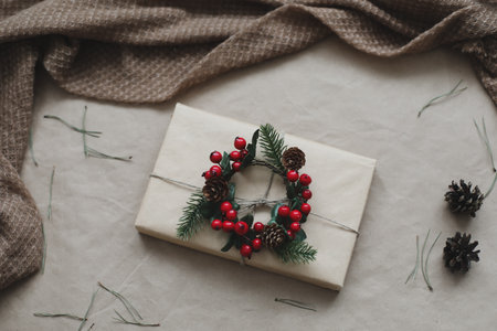 Christmas composition on craft paper background with gift box, fir branches, toys, copy space for your congratulationsの写真素材