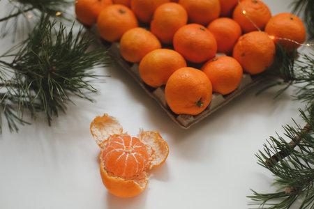 Christmas background with fir tree branches and tangerines. Merry Christmas and Happy New Year Greeting Card. Copy space. Top view. High quality photoの写真素材