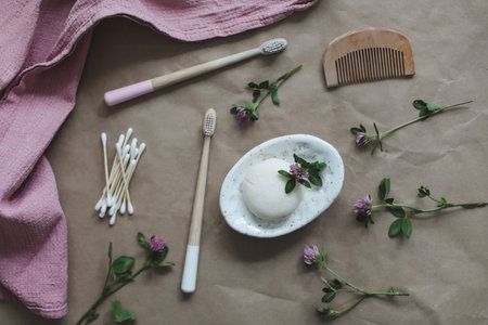 Soap bar or solid shampoo on a soap dish, bamboo toothbrush and towel top view with copyspace. Accessories for personal hygiene. Plastic free and eco friendly products in household.の写真素材
