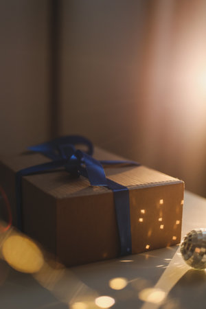 craft paper gift box with blue satin ribbon bow on table backgroundの写真素材