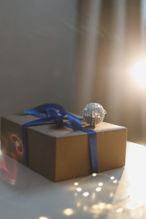 craft paper gift box with blue satin ribbon bow on table backgroundの写真素材