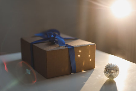 craft paper gift box with blue satin ribbon bow on table backgroundの写真素材