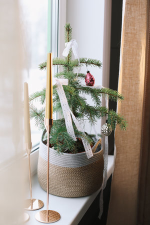 Interior design with christmas tree and candles. Home decor. New Year lace decorations for the Christmas tree in eco style. Holiday Template with Christmas decorations on fir tree.の写真素材