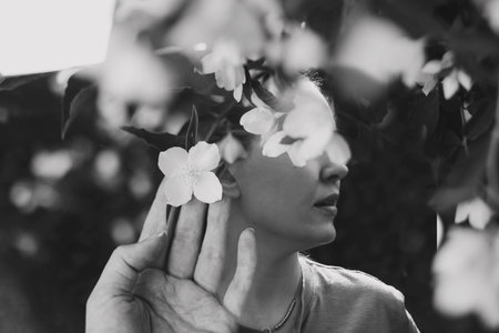 Abstract contemporary art collage black and white portrait of young woman with flowers on face hides her eyes. Creative portrait with Multiple exposure, abstract fashionable beauty photo.の写真素材