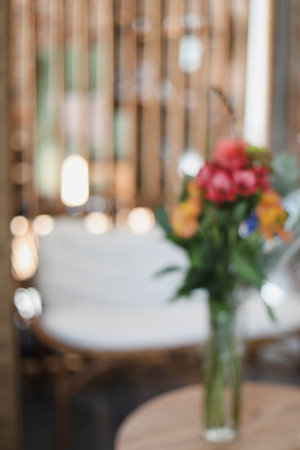 Vase of fresh tulips on the coffee table with blurred background of modern cozy light living room with gray couch sofa and graphic cushions. Open space home interior design. Copy space. Vertical card.の写真素材