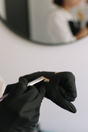 Professional makeup brushes, hand in a black glove holding makeup brush and applying foundation on a white background. place for text. Makeup, Brushesの写真素材
