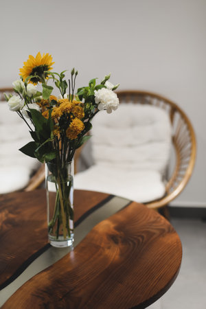 bouquet of beautiful yellow sunflower flowers in a glass vase on an old rustic wooden table. Autumn cozy home decorの写真素材