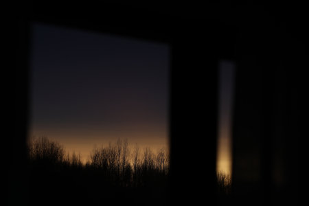 Sunset clouds mirrored in the window. Nature sunset sky backdrop. Blurry abstract sunrise backgroundの写真素材