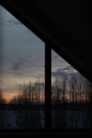 Sunset clouds mirrored in the window. Nature sunset sky backdrop. Blurry abstract sunrise backgroundの写真素材