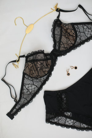 Womans silk lingerie on the white bed sheets. Valentines day concept. Lace female underwear. Beauty, fashion blogger concept. Female bra, panties.の写真素材