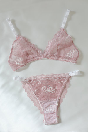 Silk lingerie on the white bed sheets. Valentines day concept. Lace female underwear. Beauty, fashion blogger concept. Female bra, panties.の写真素材