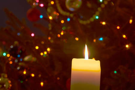 Flame of candle and Christmas tree ornamentsの写真素材