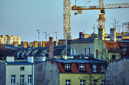 Roofs of houses, chimneys, antennas and cranes in Poznanの写真素材
