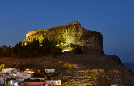 Medieval fortifications atop a rock in Lindos at nightのeditorial素材