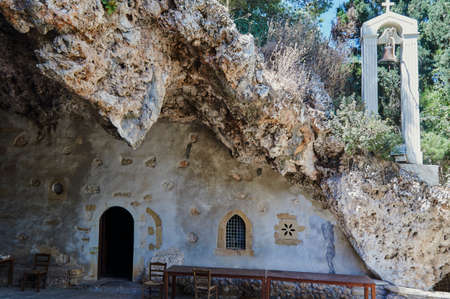 The Orthodox chapel in a cave with a bell tower on the island of Creteの写真素材
