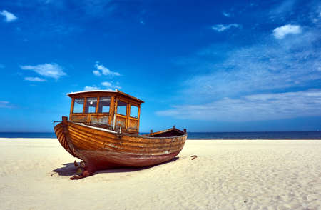 Wooden fishing boat on a sandy beach on the island of Usedom, Germanyの写真素材