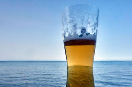 Trophy with a beer on the background of the sea in a Greek tavernaの写真素材