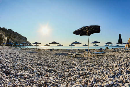 Beach umbrellas on the rocky coast of the island of Rhodesの写真素材