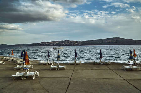 Umbrellas and beach beds on a cloudy day on the Adriatic Sea in Croatiaの写真素材