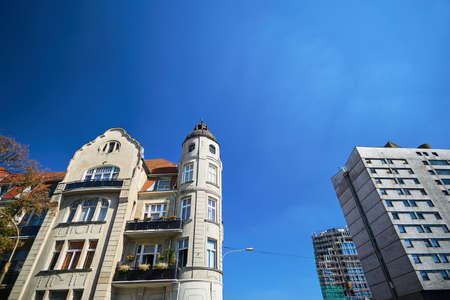 A facade of an Art Nouveau townhouse next to a modernist building in Poznan
