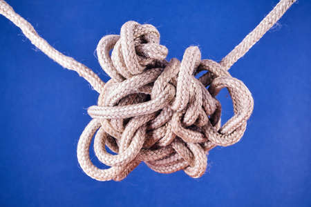 A tangled knot on a rope on a blue backgroundの写真素材