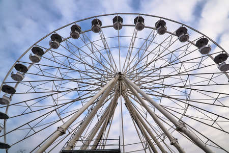 Construction and wagons of the Ferris wheel against the sky in Poznanの写真素材