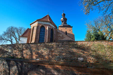 Brick, medieval wall and the Gothic parish church in Gnieznoの写真素材