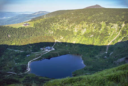Mountain cottage, lake and mountain Sniezka in the Giant Mountains in Poland