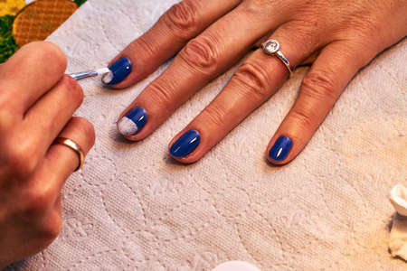 painting nails with colored, hybrid varnish