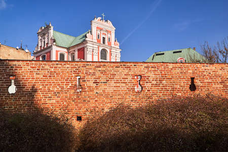 Baroque Catholic Church behind medieval defensive wall in Poznanの写真素材