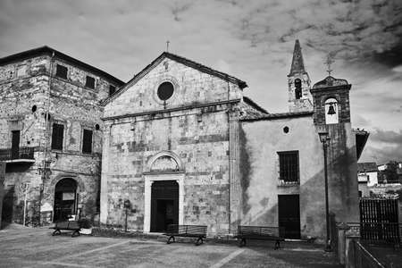 Medieval church with a bell tower in the village of Magliano in Toscana, Italy